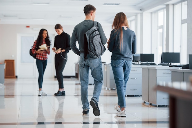 Ir à reunião Grupo de jovens a entrar no escritório na hora do intervalo