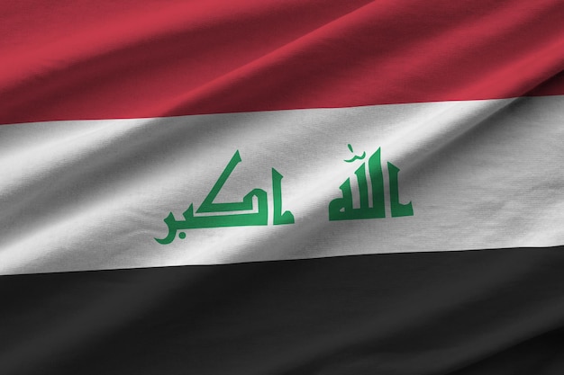 Irak-Flagge mit großen Falten, die in der Nähe unter dem Studiolicht im Innenbereich winken Die offiziellen Symbole und Farben im Banner