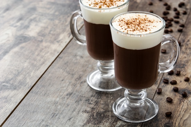 Irischer Kaffee im Glas auf hölzernem Tischkopierraum