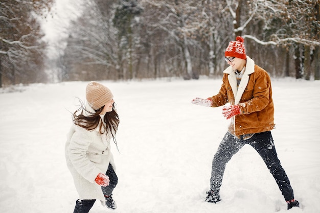 Irmão e irmã adolescentes jogam bolas de neve em winter park