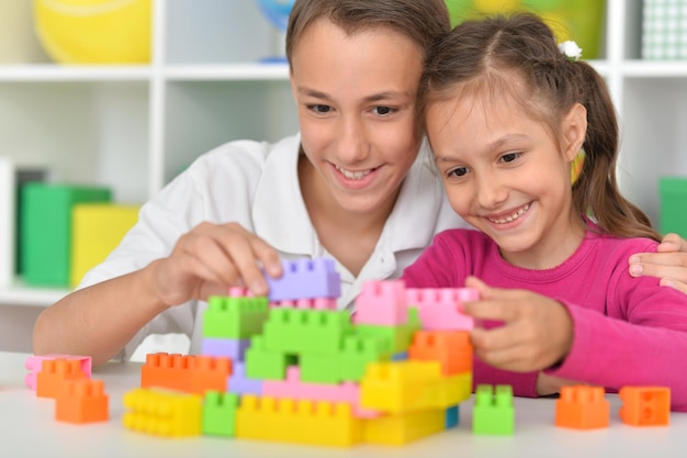 Irmão e irmã brincando com blocos de plástico coloridos juntos