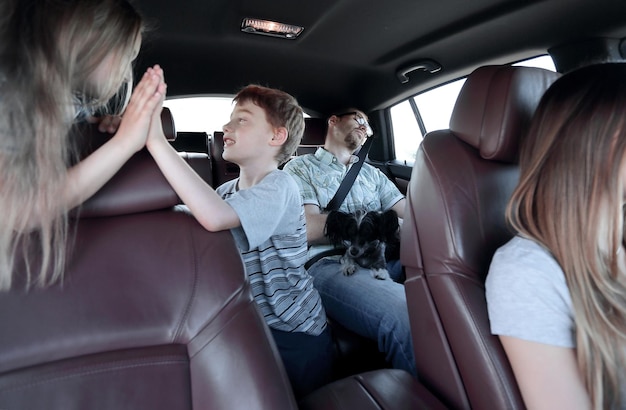 Irmão e irmã dão um high five enquanto estão sentados na cabine do carro