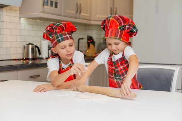 irmão e irmã estão preparando biscoitos para o ano novo espaço para texto Foto de alta qualidade