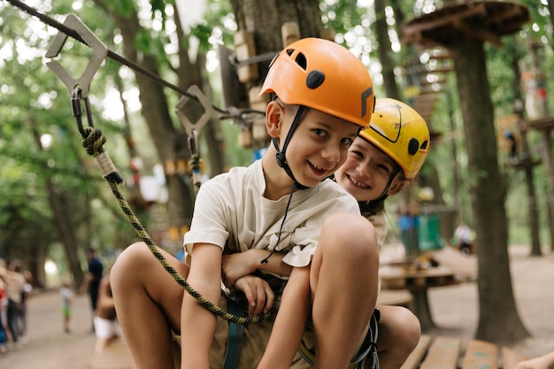 Irmão e irmã se divertindo no parque de cordas de aventura