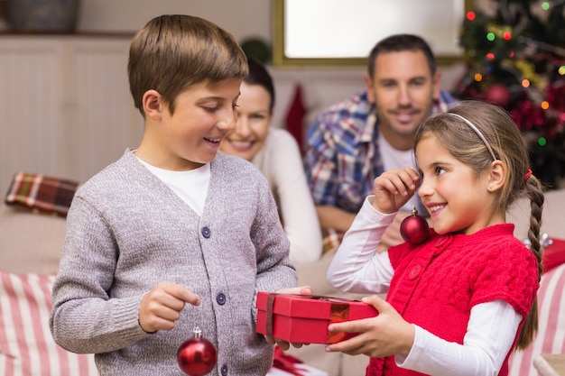 Irmão e irmã segurando presentes e baubles