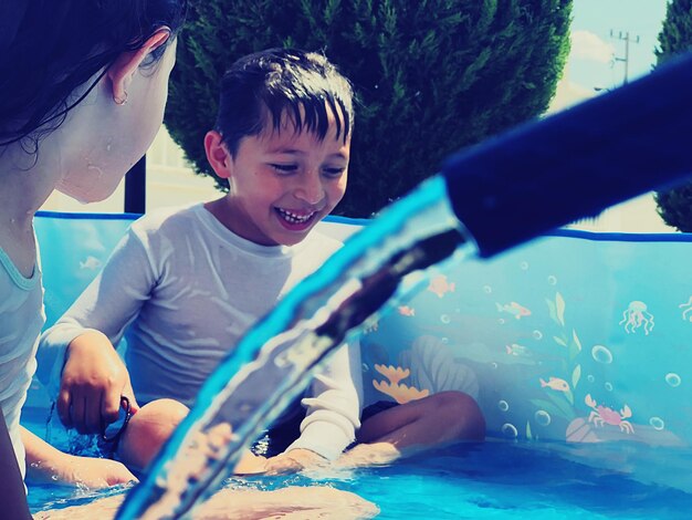 Irmãos a brincar na piscina