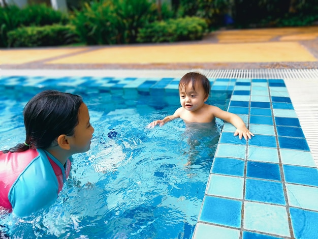 Irmãos a nadar na piscina