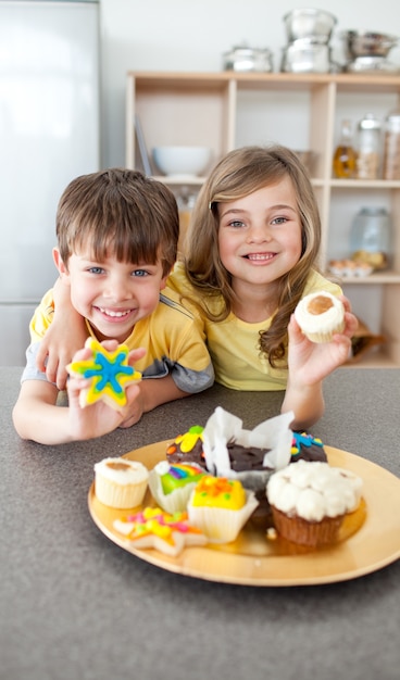 Irmãos adoráveis ​​que mostram seus cookies