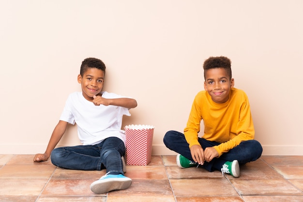 Irmãos afro-americanos segurando pipocas