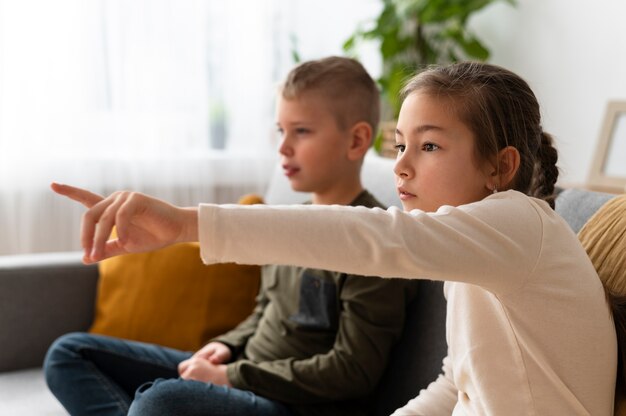 Foto irmãos assistindo televisão juntos