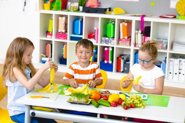Irmãos bonitos a comer frutas em casa.