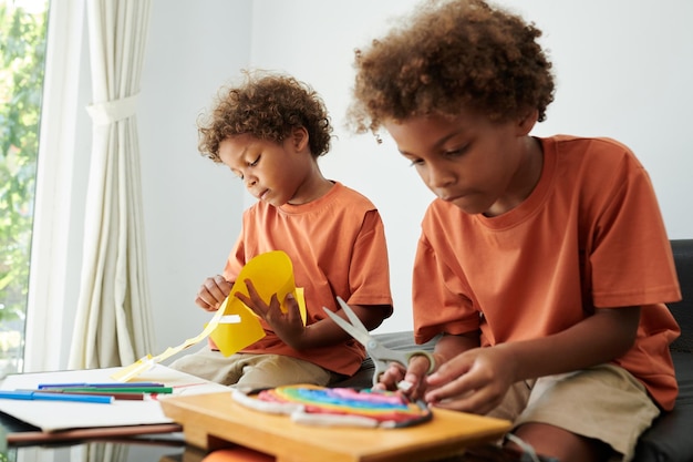 Irmãos criativos fazendo artesanato com papel colorido e barro moldado