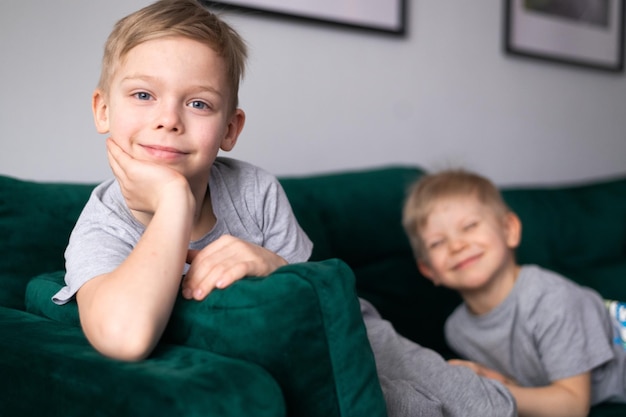 Irmãos de meninos felizes posando no sofá em casa