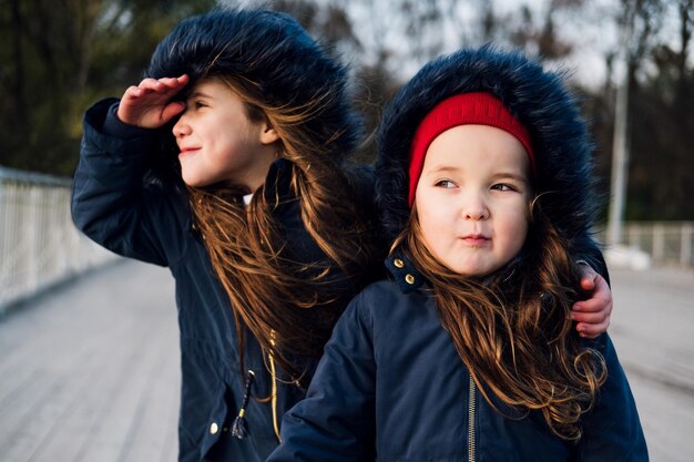 Foto irmãos de pé no caminho durante o inverno