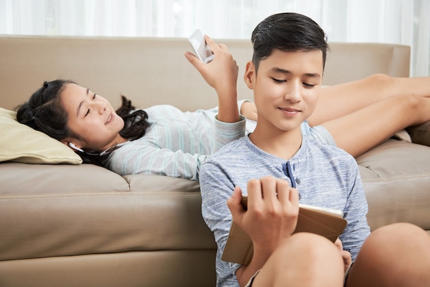 Irmãos descansando com gadgets