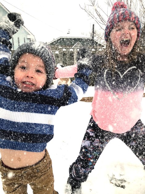 Irmãos desfrutando da neve ao ar livre