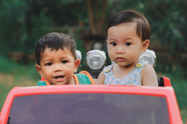 Foto irmãos em um carro de brinquedo