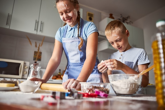 Irmãos habilidosos preparando massa enquanto trabalham na cozinha