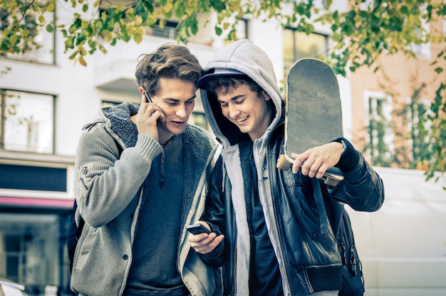 Irmãos hipster jovens se divertindo com smartphone
