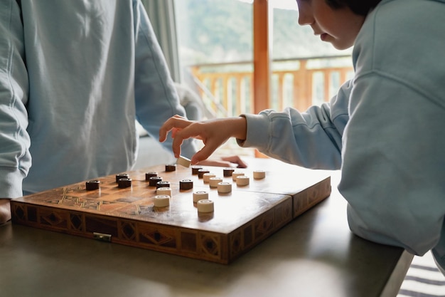 Irmãos jogando damas em casa irmãos jogando o jogo de estratégia de tabuleiro passando tempo juntos