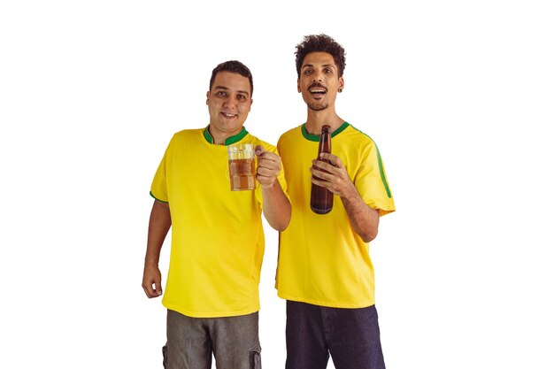 Irmãos negros com camisa amarela brasileira e garrafa de cerveja torcendo isolados em branco