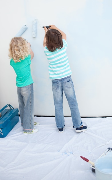 Irmãos pintando uma parede