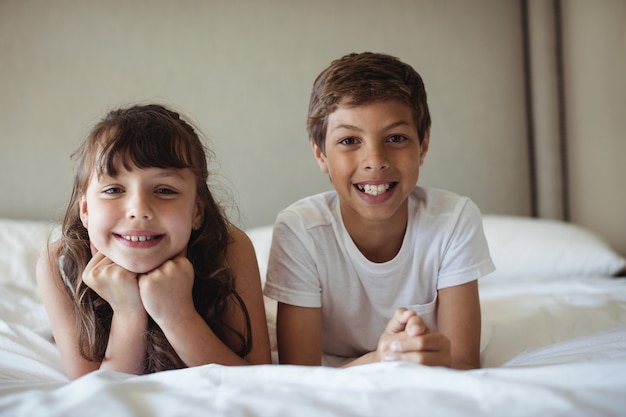 Irmãos sorrindo na cama