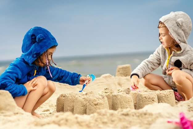 Irmãs a fazer castelos de areia na praia
