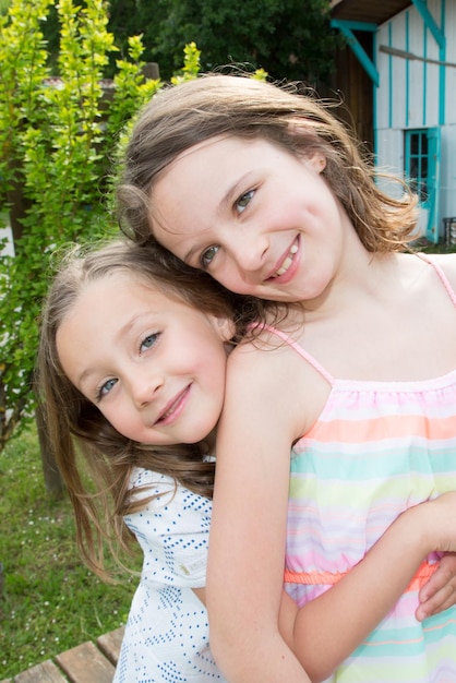 Irmãs de garotas engraçadas felizes abraçando e sorrindo