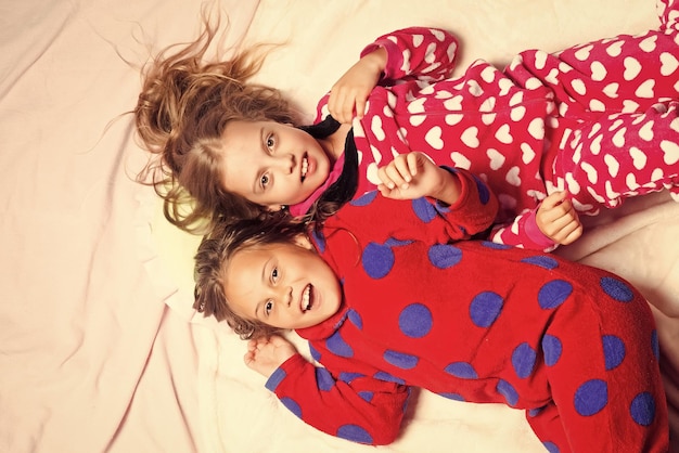 Foto irmãs de pijama sorriso feliz na vista superior da cama