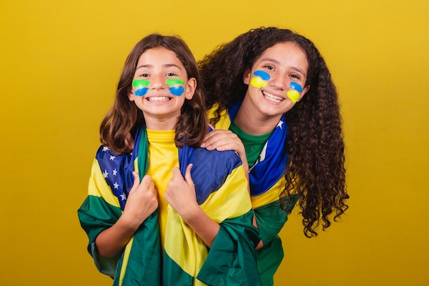 Irmãs e amigos torcedores dos fãs de futebol do Brasil sorrindo para a câmera assistindo o jogo do Brasil nas Olimpíadas da Copa do Mundo