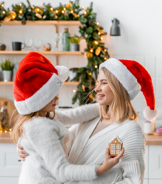 Foto irmãs fofas se divertem na cozinha aproveitando o natal com biscoito de natal