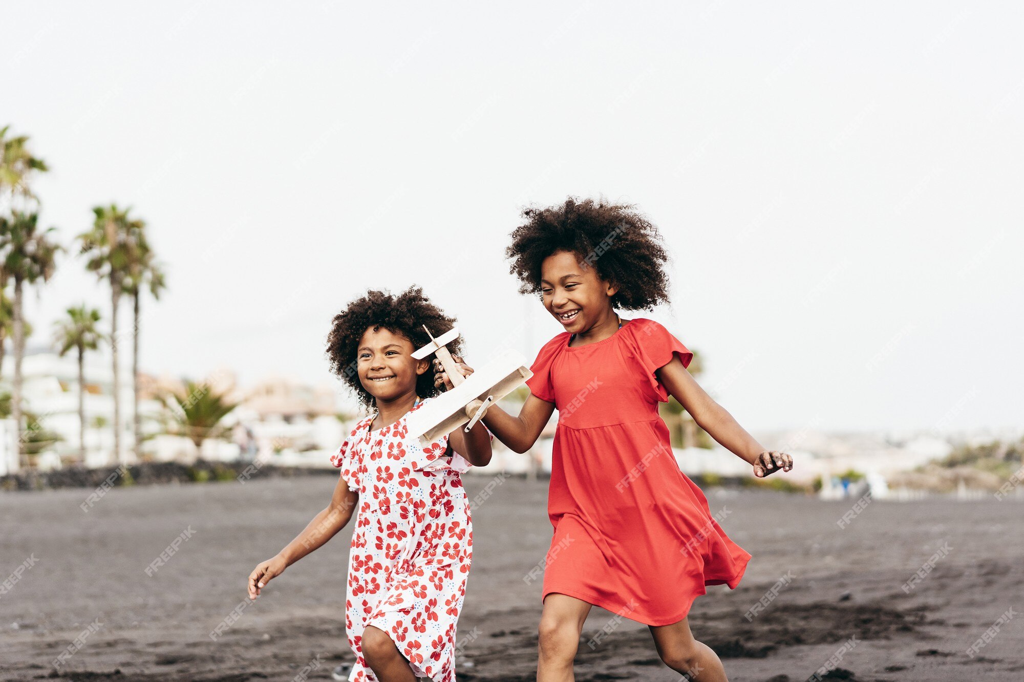 Foto Namoradinhas negras sentadas em banco de madeira e brincando ao ar  livre. Conceito de infância. Ideia de amizade. Estilo de vida infantil  moderno. Meninas morenas cacheadas alegres. Ensolarado durante o dia –