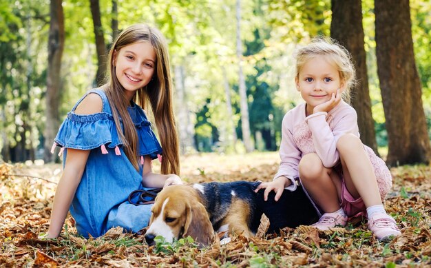 Irmãs jovens brincando com cachorro beagle