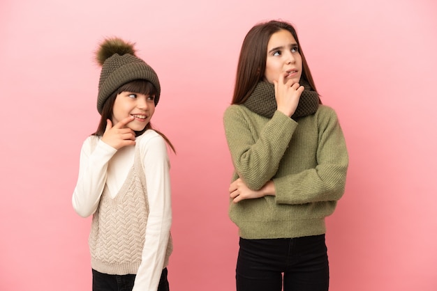 Irmãs mais novas com roupas de inverno isoladas