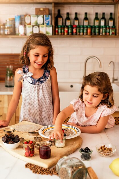 Irmãs mais novas preparando biscoitos. Conceito de chef infantil.