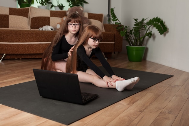 Irmãs pequenas dão aulas de ginástica online em casa