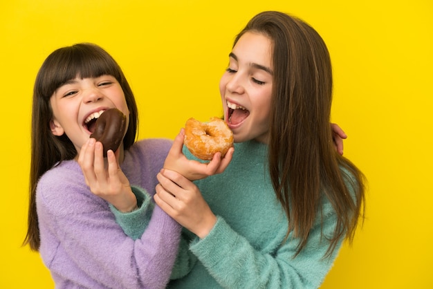 Irmãs segurando uma rosquinha sobre fundo isolado