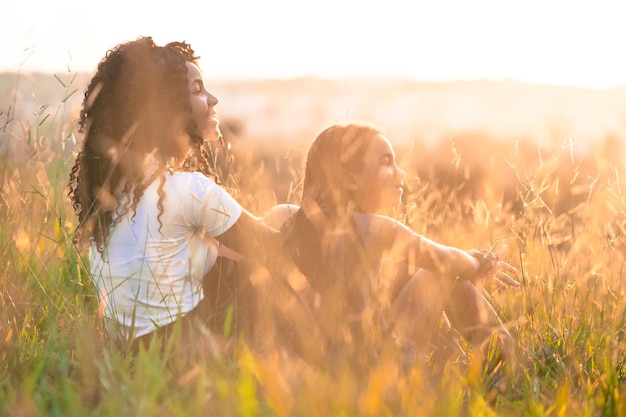 Irmãs sorridente sentadas em meio a plantas