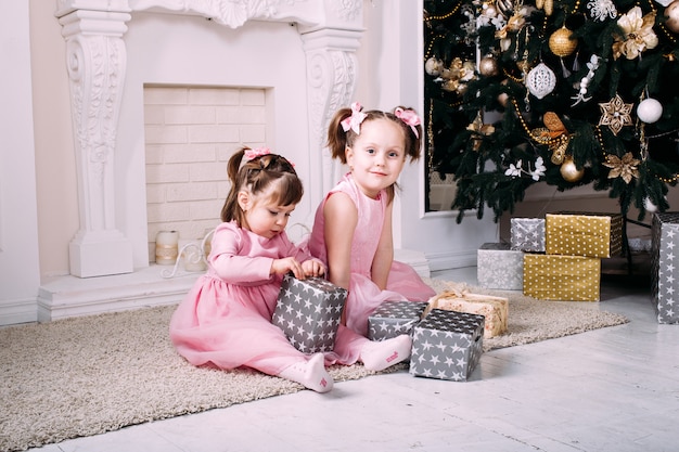 Irmãs sorridentes felizes com caixas de presente de Natal.