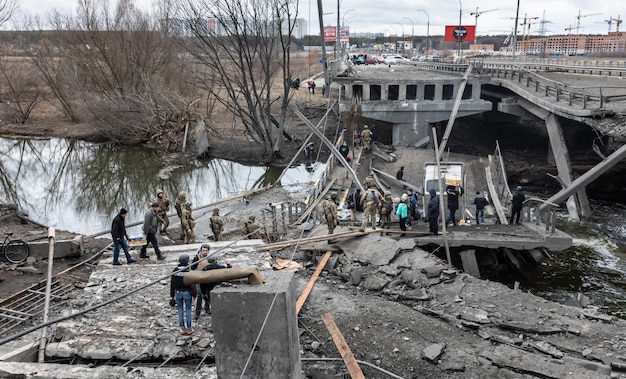 IRPIN UCRÂNIA 05 de março de 2022 Guerra na Ucrânia Pessoas atravessam uma ponte destruída enquanto evacuam a cidade de Irpin a noroeste de Kiev durante bombardeios e bombardeios pesados