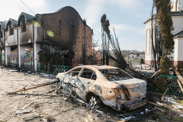 IRPIN UCRÂNIA 09 de março de 2022 Guerra na Ucrânia Caos e devastação nos arredores de Irpin Igreja danificada e carro queimado como resultado do bombardeio de uma cidade pacífica