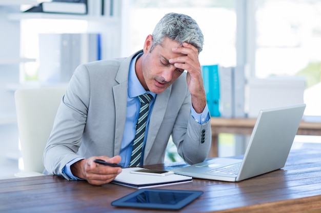 Irritado hombre de negocios tratando de trabajar