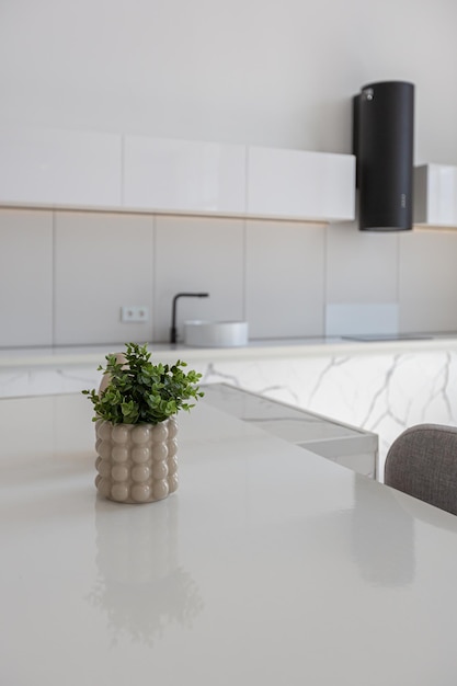 Isla de cocina y comedor con taburetes altos en un diseño de lujo minimalista moderno de una casa cara en un día soleado paredes blancas con iluminación decorativa de parquet de yeso y nadie dentro