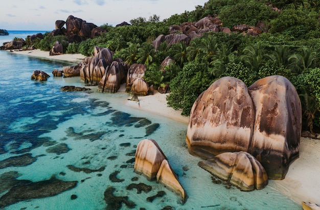Isla "La digue" en Seychelles. Playa de plata con piedra granítica y selva. Hombre disfrutando de vacaciones y relajarse en la playa. Vista aérea