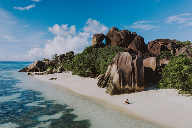 Isla "La digue" en Seychelles. Playa de plata con piedra granítica y selva. Hombre disfrutando de vacaciones y relajarse en la playa. Vista aérea