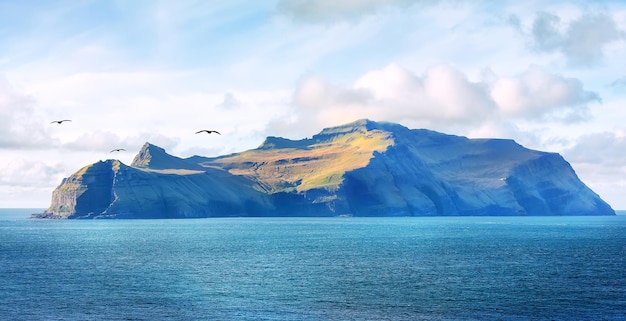 Foto isla gasholmur bajo la luz del sol mañana tranquila en las islas feroe dinamarca