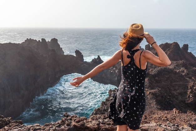 Isla de El Hierro Islas Canarias un joven turista visitando el monumento Arco de la Tosca en la costa