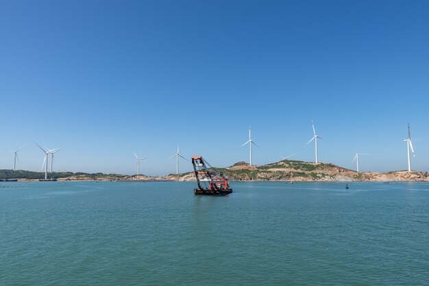En la isla en medio del mar, muchas turbinas eólicas están instaladas bajo el cielo azul.