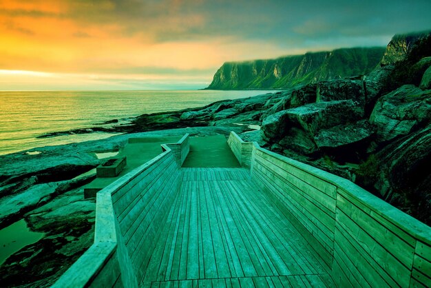 Isla Senja al atardecer Costa rocosa Pasarela de madera a la playa